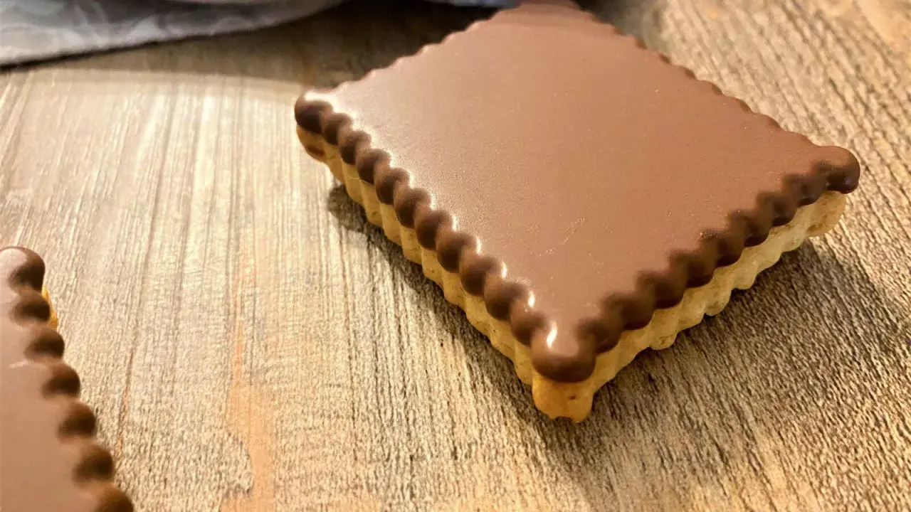 Un délicieux petit écolier maison, recouvert de chocolat, sur une table en bois.
