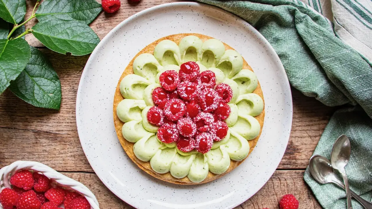 Délicieuse recette tarte pistache framboise, ornée de fruits rouges frais et d'une crème onctueuse. Un régal visuel et gustatif.