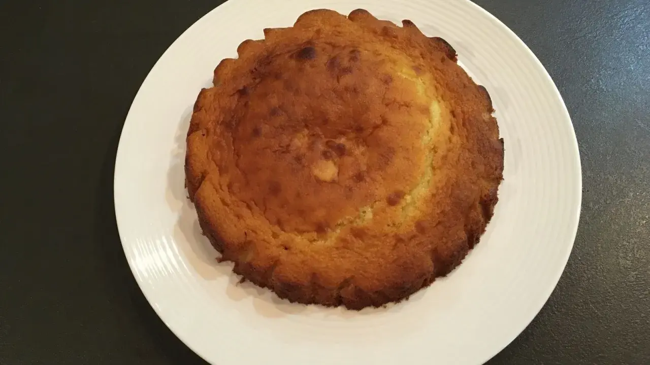 Un biscuit madeleine rond, doré et légèrement bombé, prêt à être transformé en un délicieux entremet.