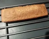 Une buche dorée, comme un biscuit madeleine, refroidit sur une grille.