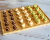 Plateau de mini tartelettes sucrées : chocolat, meringue et pistache. Un délice pour les yeux et les papilles.