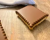 Un délicieux petit écolier maison, recouvert de chocolat, sur une table en bois.