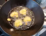 Des beignets de butternut dorent dans l'huile chaude d'une poêle.