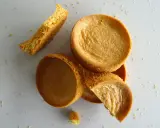 Des morceaux de sablé breton moelleux, certains entiers, d'autres brisés, éparpillés sur un fond clair.