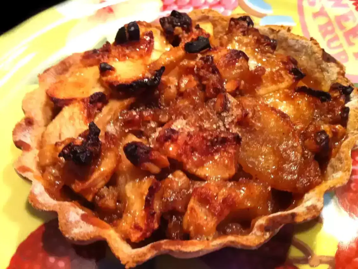 Tartelette aux pommes caramélisées sur pâte brisée sans beurre. Un délice croustillant et fruité.