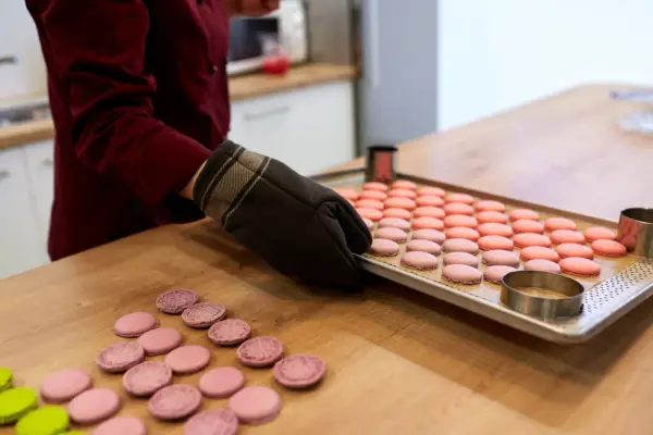 Préparation pour la cuisson macaron chaleur tournante : une plaque de macarons roses et roses est sortie du four.