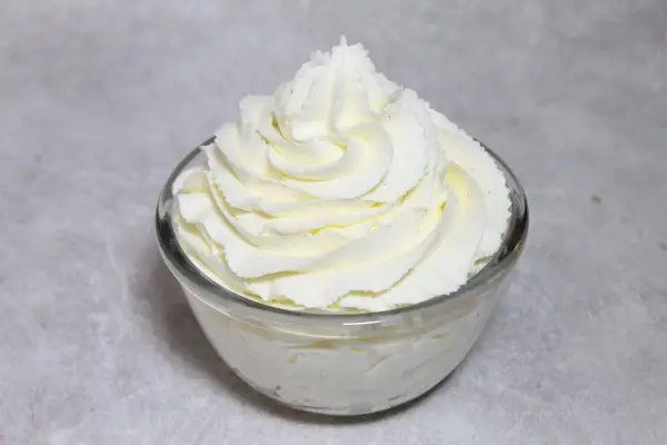 Chantilly au robot pâtissier, aérienne et onctueuse, dressée en rosace dans un bol en verre. Parfait pour garnir vos desserts.