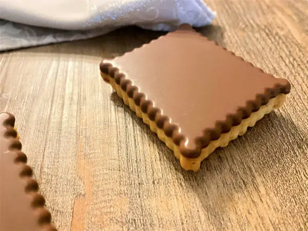 Un délicieux petit écolier maison, recouvert de chocolat, sur une table en bois.