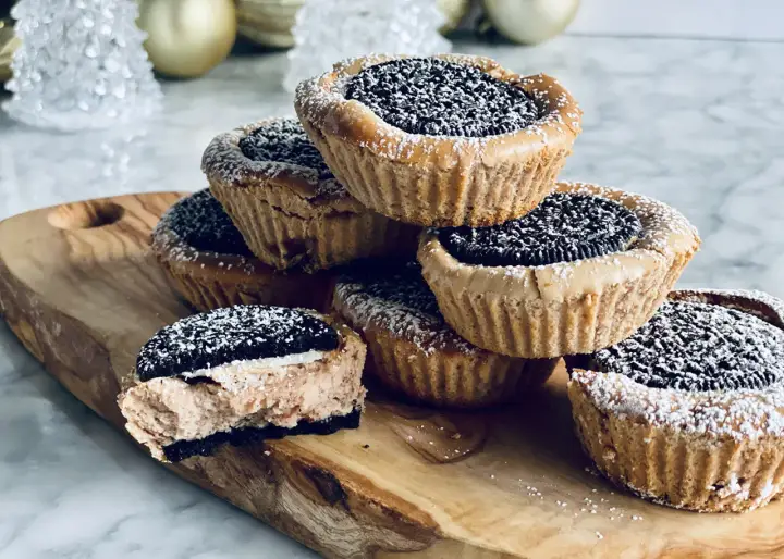 Une pile de petites bouchées sucrées faciles à faire, garnies d'un biscuit Oreo et saupoudrées de sucre glace. Parfaites pour une pause gourmande.