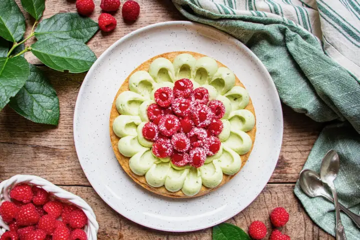 Délicieuse recette tarte pistache framboise, ornée de fruits rouges frais et d'une crème onctueuse. Un régal visuel et gustatif.