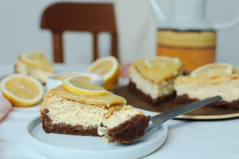 Tranches de cheesecake au citron, garnies d'une tranche de citron frais. Parfait pour une recette coulis de citron pour cheesecake.