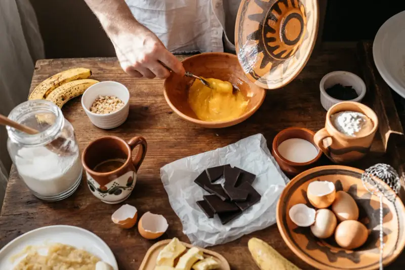 Préparation d'une recette avec des ingrédients comme des œufs, des bananes et du chocolat qui ne fond pas.